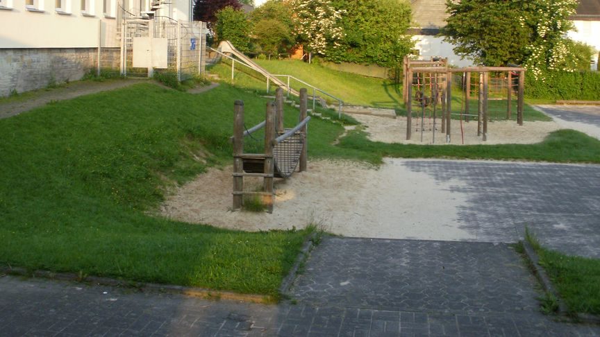 Der Spielschulhof mit Klettergerüsten und Rutsche